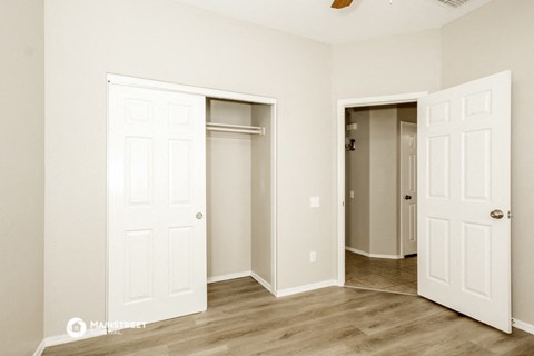a bedroom with two closets and a door to a closet