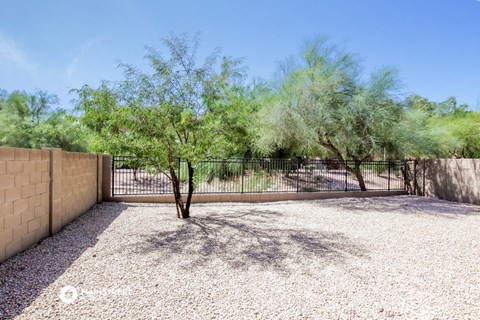 the backyard of a house with a fence and trees
