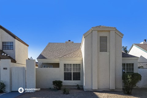 a white house with a turret and a white fence