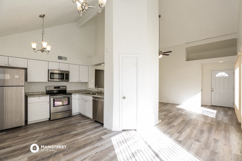 an open kitchen with white cabinets and stainless steel appliances