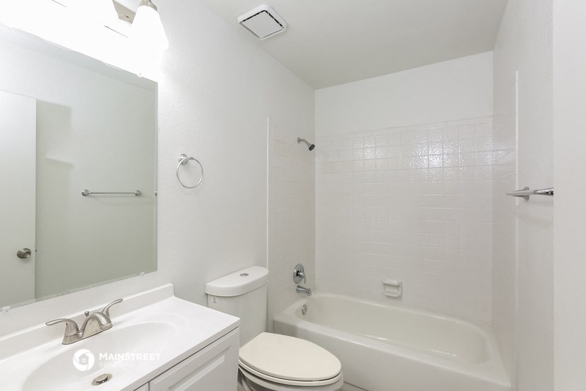 a white bathroom with a tub and a sink and a toilet