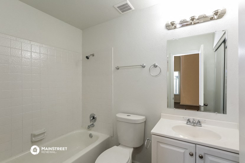 a white bathroom with a tub and a toilet and a sink