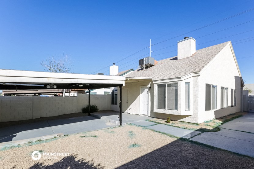 a small white house with a garage and a roof