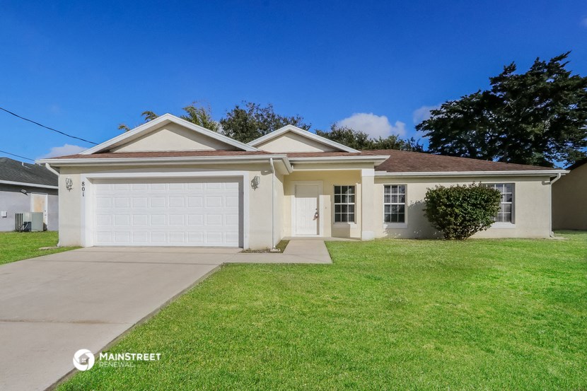 a white house with a driveway and a lawn