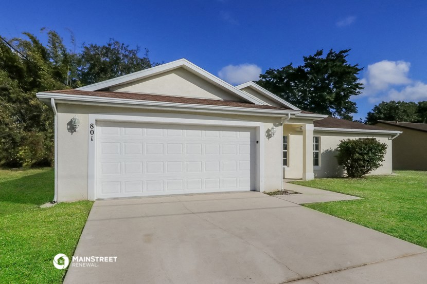 a home with a white garage door and a driveway