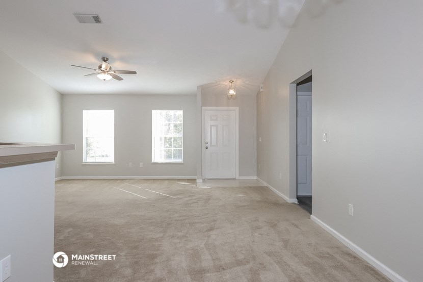 the spacious living room with a ceiling fan in a new home