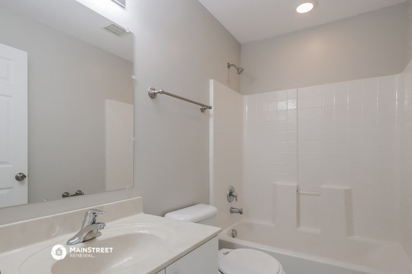 a white bathroom with a sink and a tub and a toilet