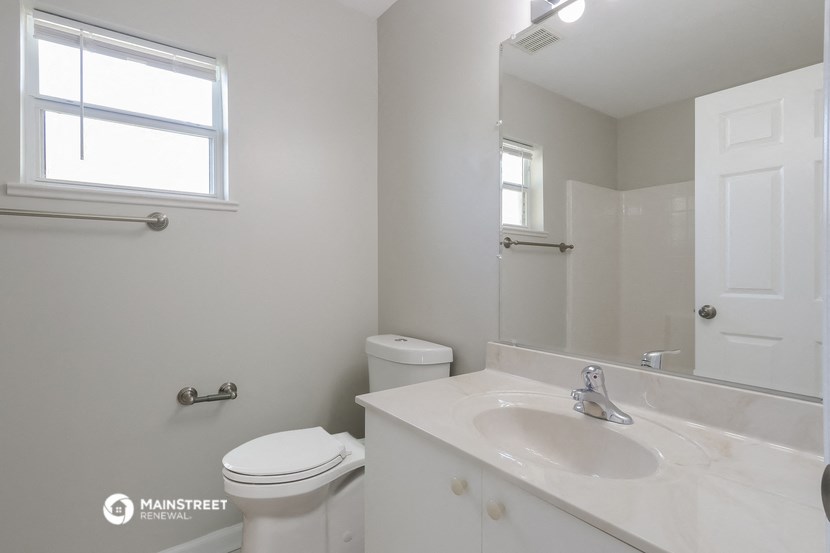 a bathroom with a sink toilet and a mirror
