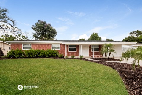 a red brick house with a lawn in front of it