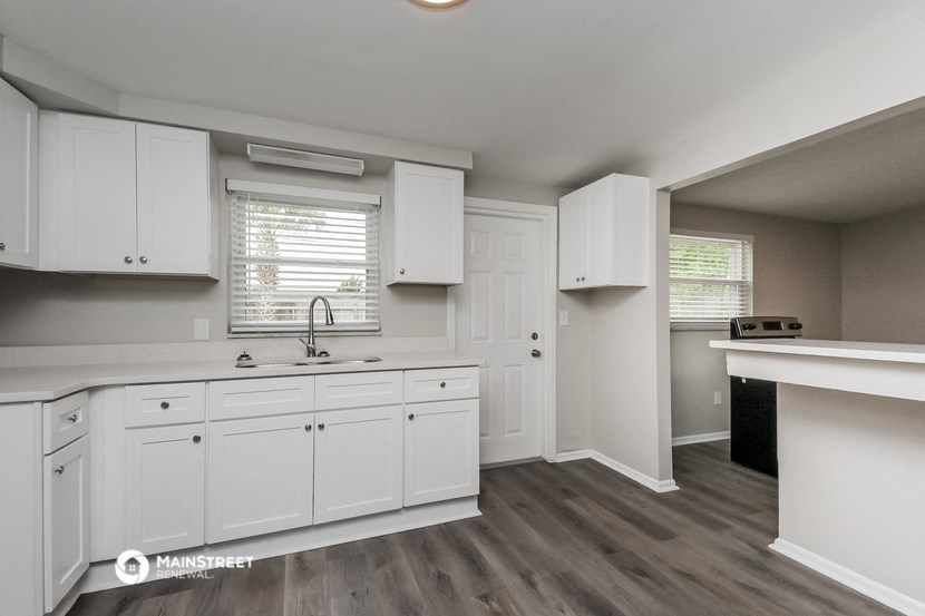 a white kitchen with white cabinets and a sink