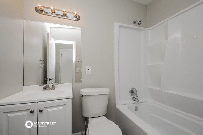a white bathroom with a white sink and toilet and a tub