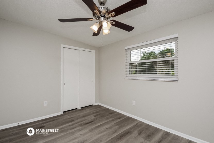 the living room of our studio apartment atrium with ceiling fan and window