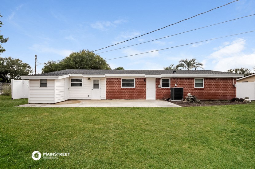 a white and red brick house with a lawn and a driveway