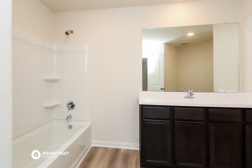 a bathroom with a tub and a sink and a mirror
