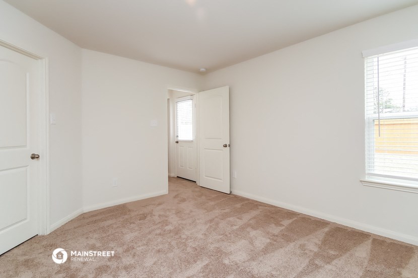 a bedroom with a door to a closet and a window