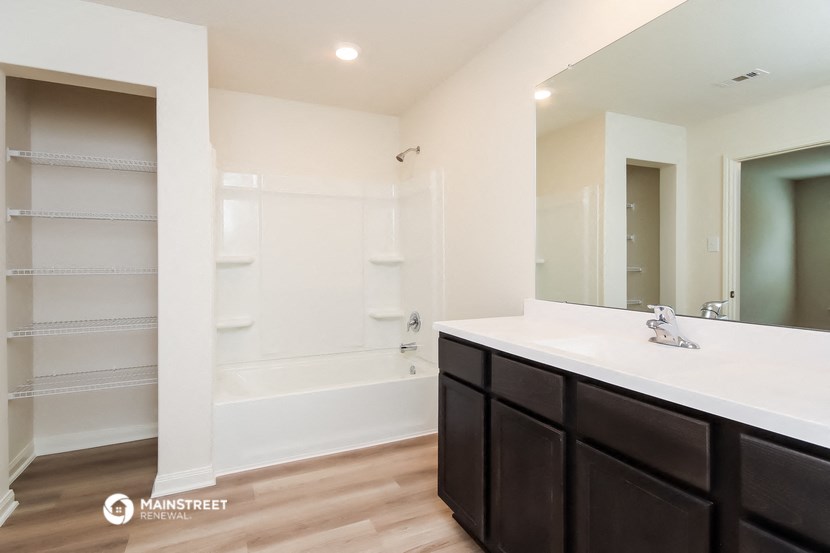a bathroom with a sink and a shower and a mirror