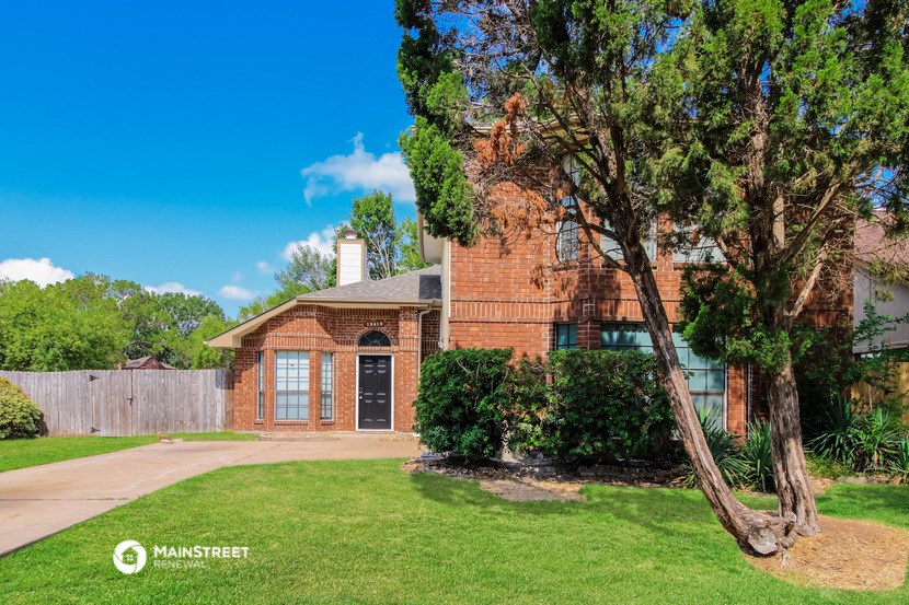 an old brick house with a tree in front of it