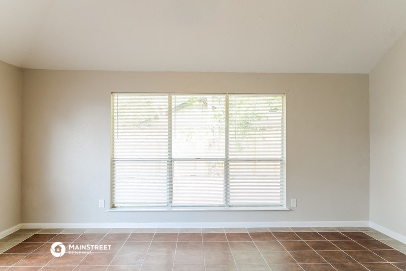the living room of an empty house with a large window