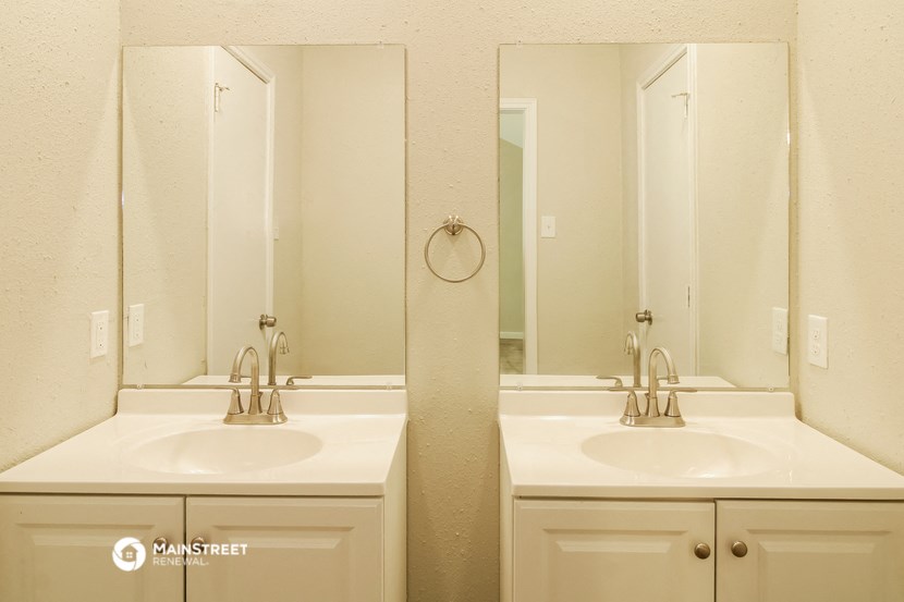 a bathroom with two sinks and two mirrors