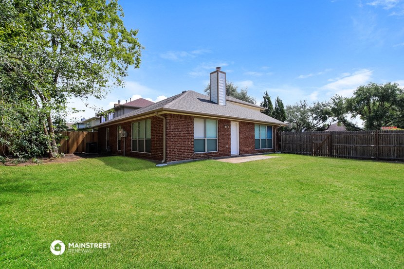 a brick house with a yard and a wooden fence