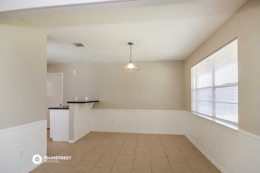 an empty living room with a large window and a table
