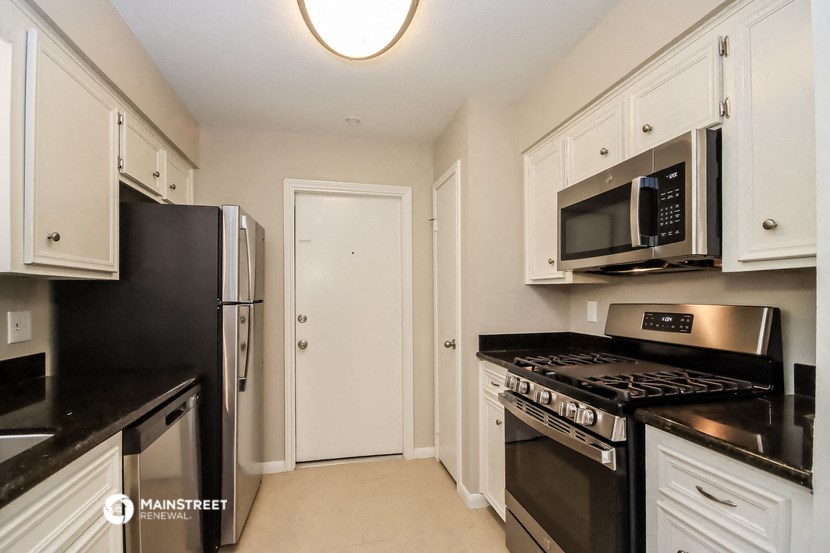 a kitchen with a stove and a refrigerator and a microwave