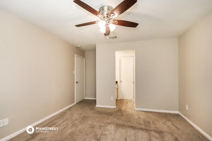 a empty living room with a ceiling fan