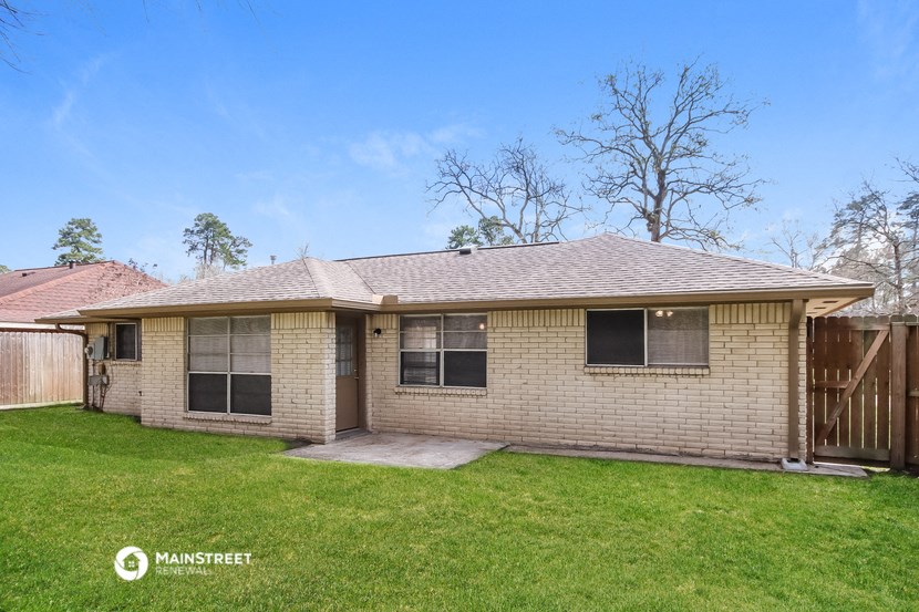 a brick house with a yard and a wooden fence