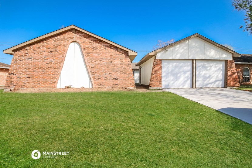 a house with a garage and a lawn in front of it