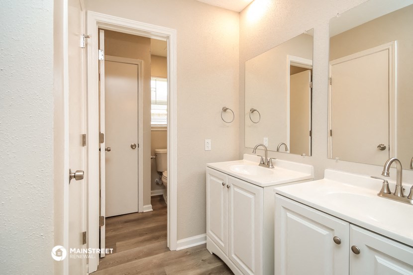 a bathroom with two sinks and a large mirror