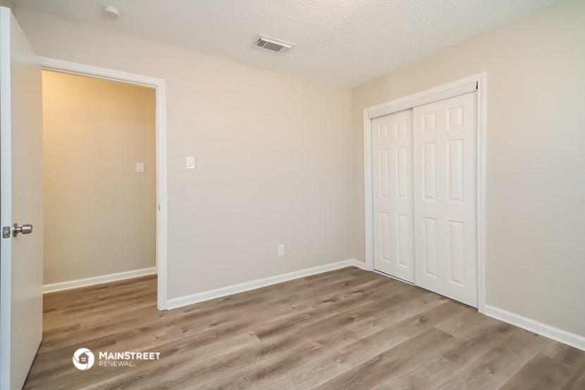 a bedroom with a door and a door to a closet