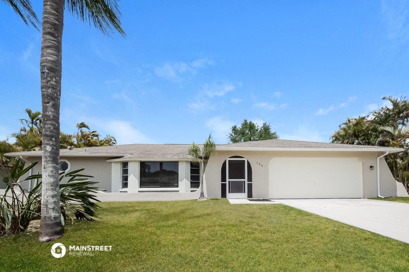 a white house with a palm tree in front of it