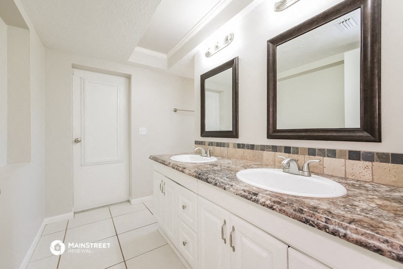a bathroom with two sinks and two mirrors