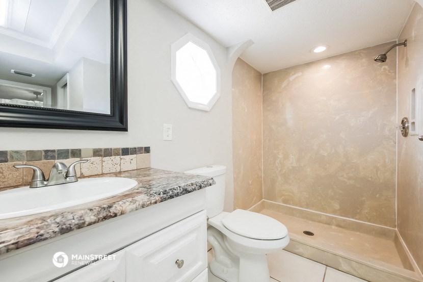 a bathroom with a toilet and a sink and a shower