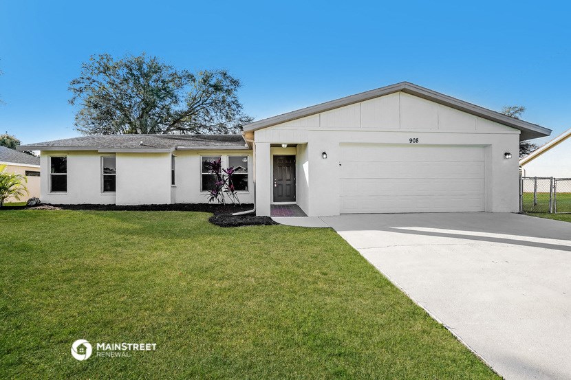 a white house with a lawn and a driveway