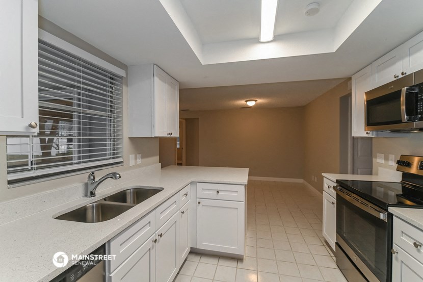 a kitchen with white cabinets and a sink