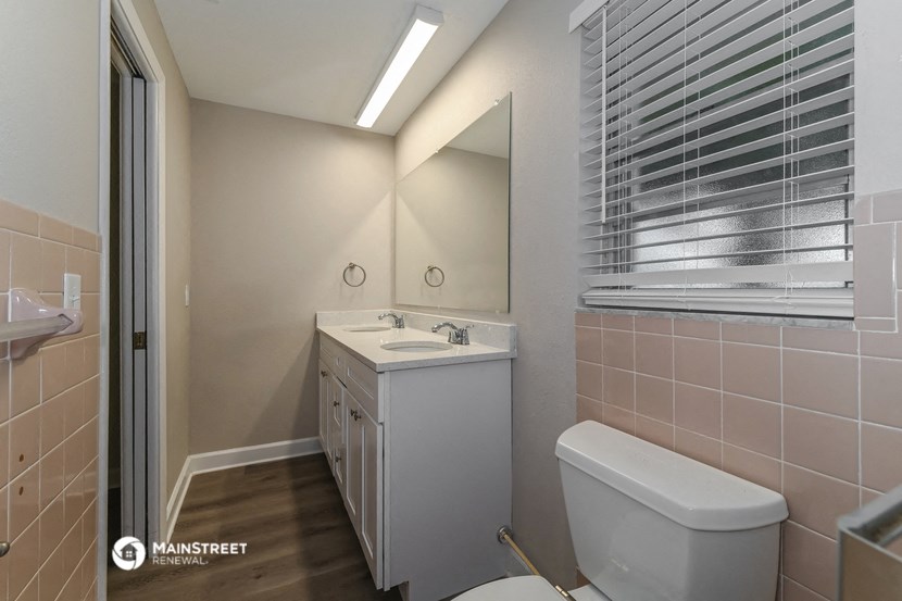 a bathroom with a toilet sink and mirror and a shower