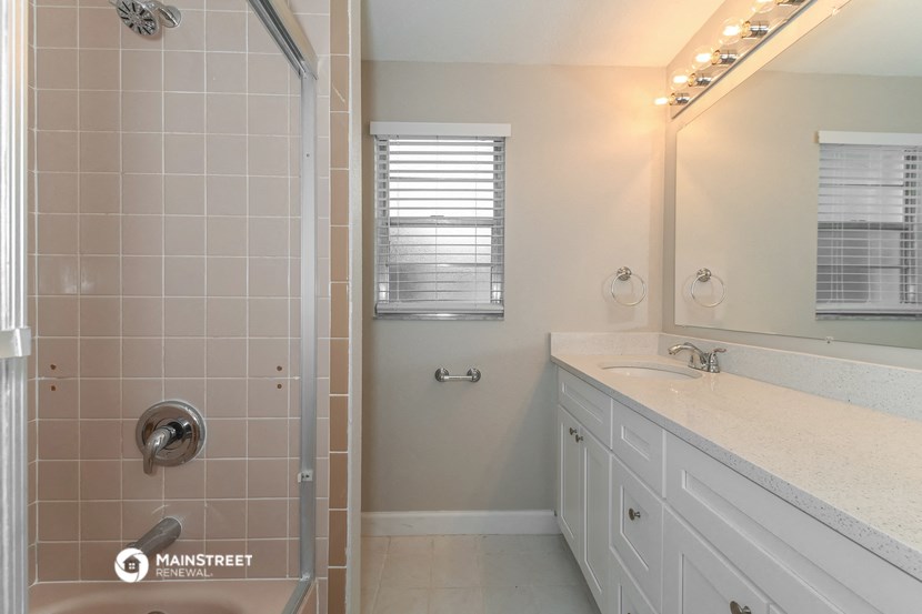 a bathroom with a shower and a sink and a mirror