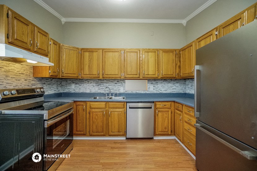 a kitchen with wooden cabinets and stainless steel appliances
