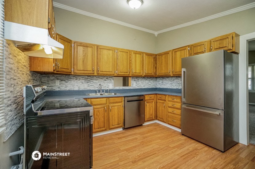 a kitchen with wooden cabinets and stainless steel appliances