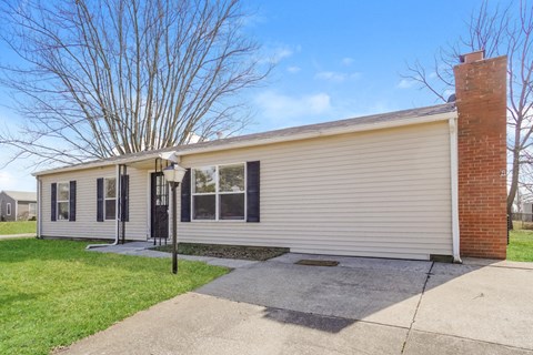 a small white house with a sidewalk in front of it