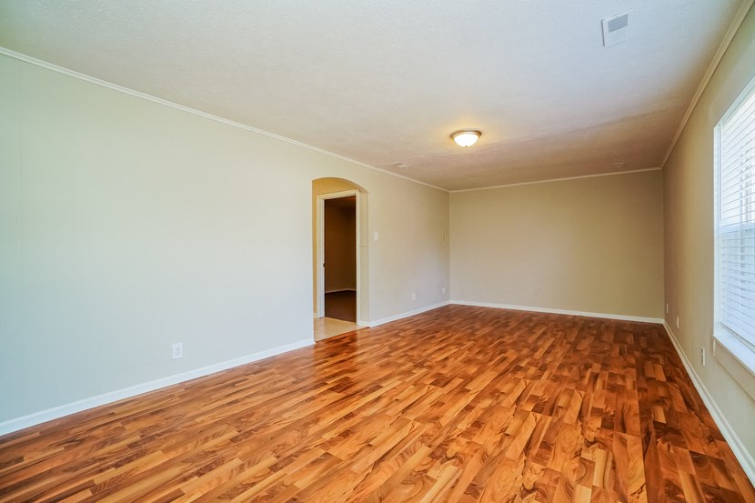 an empty living room with a hard wood floor