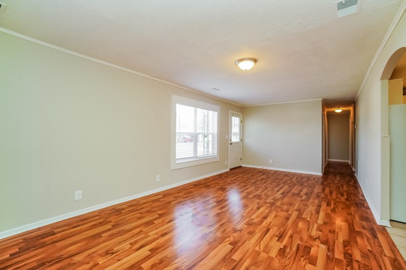 the living room and dining room of an empty house with wood floors