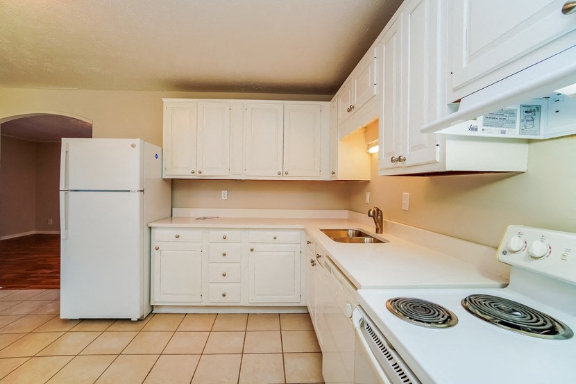 a kitchen with white appliances and white cabinets