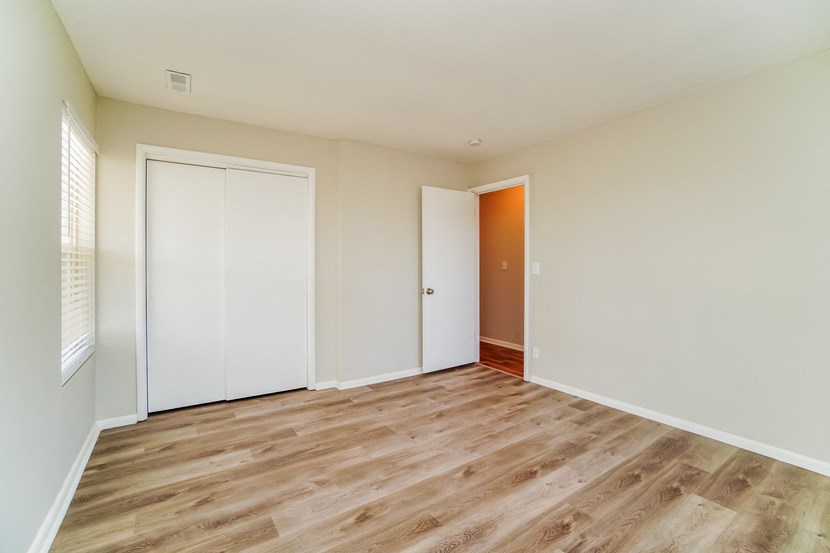 an empty living room with wood flooring and white walls