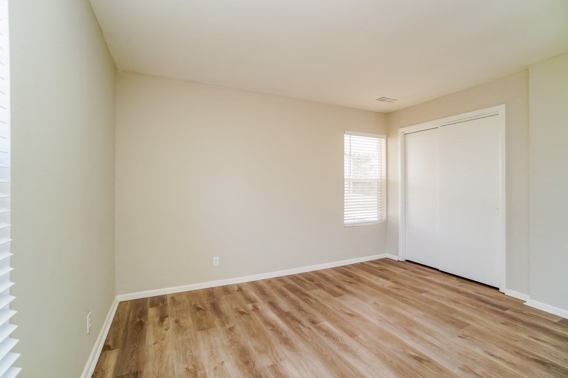 an empty room with wooden floors and a white door