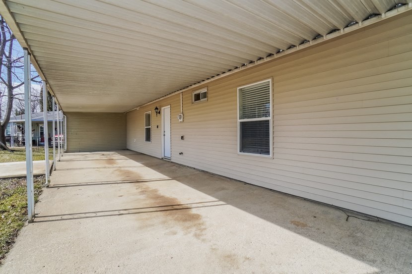 the porch of a house with a long concrete driveway