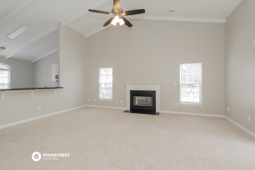 the living room with fireplace and ceiling fan