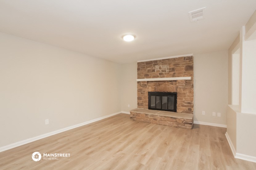 a living room with a fireplace and a wooden floor
