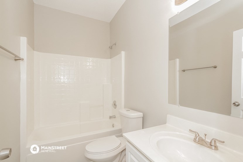 a white bathroom with a sink toilet and shower